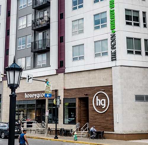 A modern building with a green sign on the side. at Walnut on Highland, Pittsburgh, PA