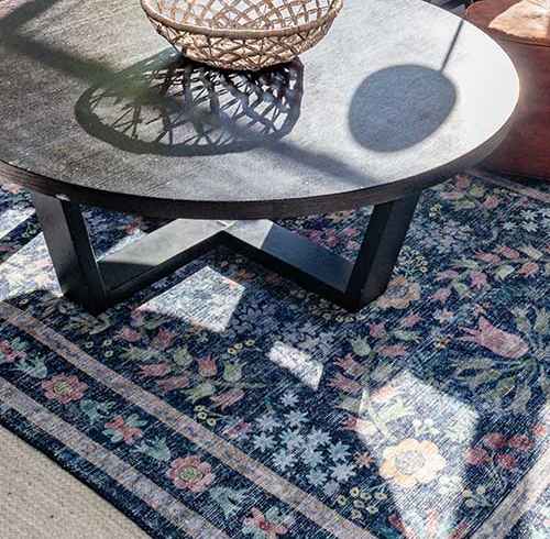 A living room with a grey sofa, a round table and a potted plant at Walnut Towers at Frick Park, Pittsburgh, PA