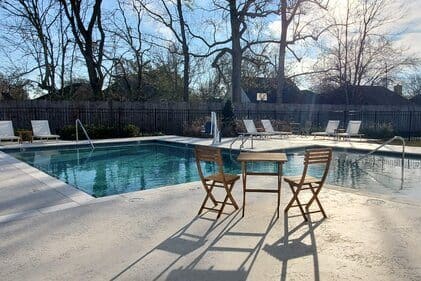 a swimming pool with a table and chairs next to it