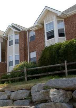 A row of houses with a stone wall in front.