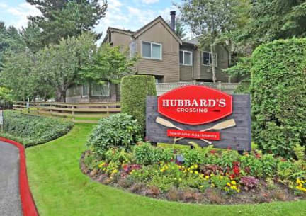 a sign for the hubbards crossing neighborhood in front of a house