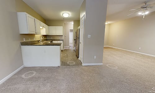 A kitchen with a sink, cabinets, and a countertop.