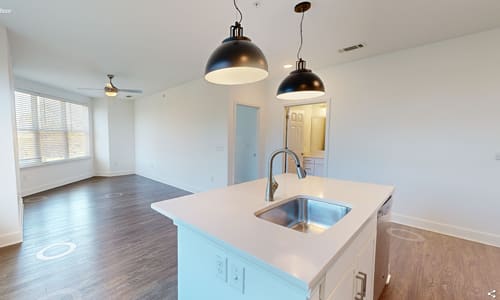 A kitchen with a sink and a countertop with a light on.