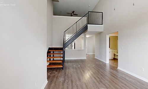 A staircase with a black railing and wooden steps leads to a second floor.