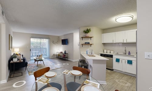 A well-lit, spacious kitchen and dining area with modern furniture and appliances.
