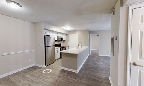 A kitchen with a refrigerator, microwave, and oven.