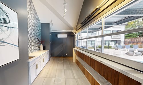 A modern kitchen with a large window overlooking a patio.