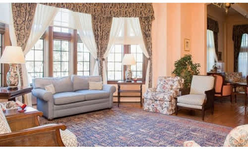 A living room with a grey sofa, a patterned armchair, and a wooden coffee table.