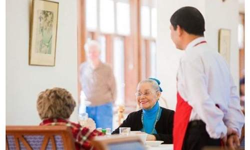 A waiter is serving a table with a woman and a child.