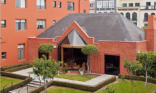 A red brick house with a black roof and a glass door.