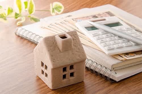 a model house sitting on a table next to a calculator