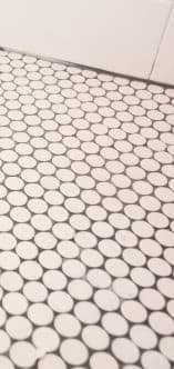 a bathroom with white tiles and a white floor