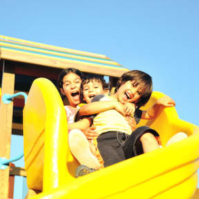 Children sliding down a slide together