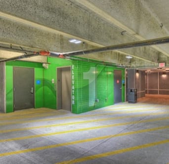 the inside of a parking garage with green doors