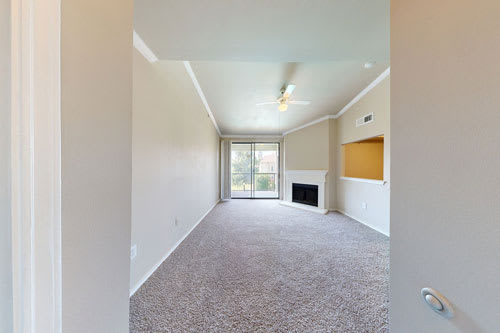 A room with a carpet floor and a fireplace.
