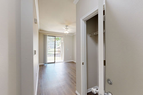 A white door is open to a hallway with a wooden floor.