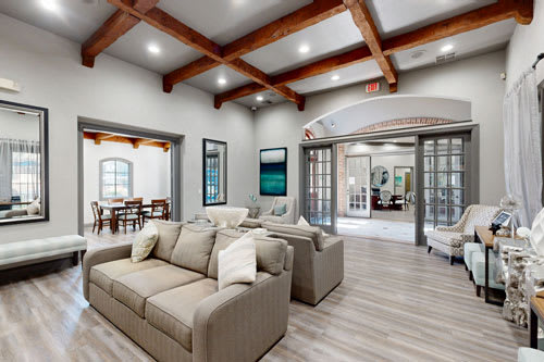 A spacious living room with a large couch and a wooden ceiling.