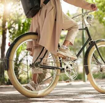 A person in a beige coat is riding a bicycle.