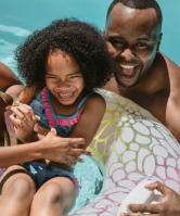 Two adults and a child in an innertube  in a pool