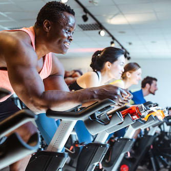 Several people riding on stationary bikes