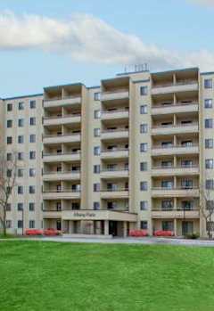 A large apartment building with a green lawn in front.