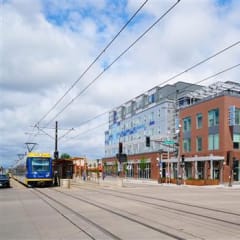 a train traveling down tracks next to a tall building