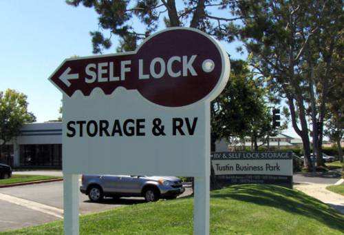 A sign pointing to the left for self lock storage and RV.