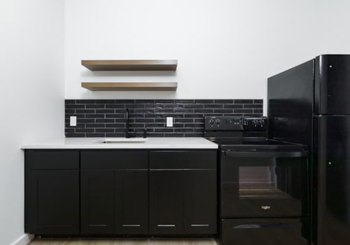 A black kitchen with a black oven and black cabinets.