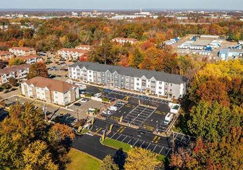 An aerial view of a parking lot in front of apartment buildings.