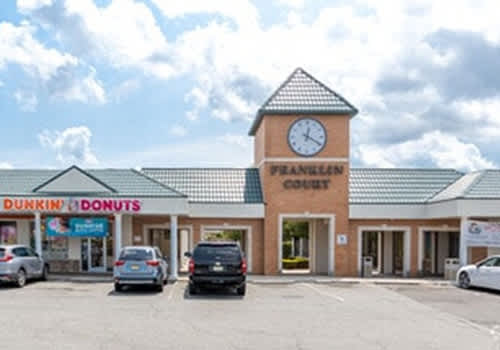 A two-story apartment building with a parking lot in front.