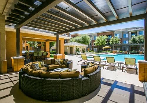 a clubhouse with a swimming pool and patio furniture