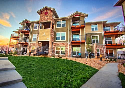 an exterior view of an apartment building at sunset