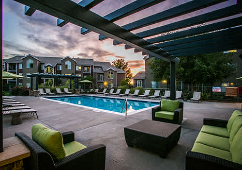 a swimming pool with lounge chairs at dusk