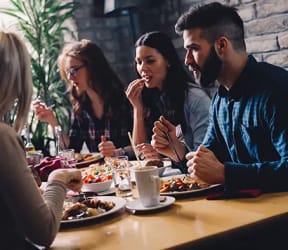 a group of people sitting around a table eating food