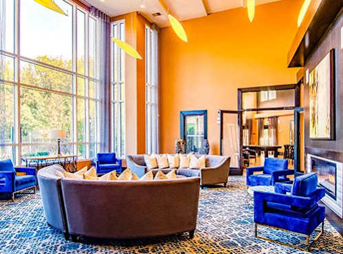 A living room with a large brown couch and blue chairs.