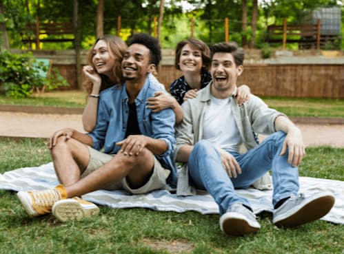 A family of four hugging outside a house.