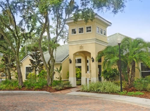 a house with a driveway and trees in front of it
