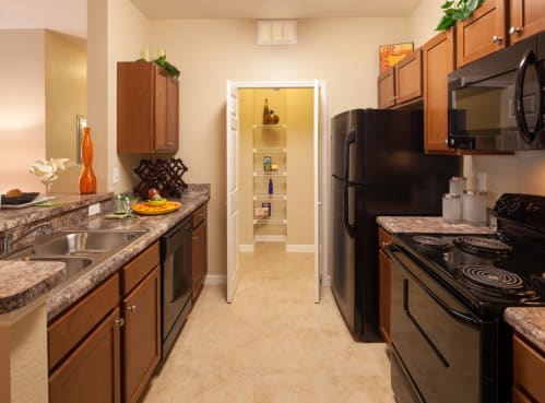 a kitchen with a black refrigerator freezer next to a black stove top oven