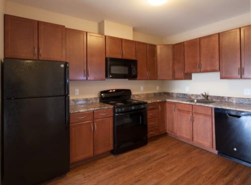 a kitchen with wooden cabinets and black appliances