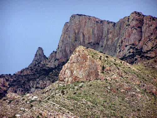 a rocky mountain with a mountain range in the background