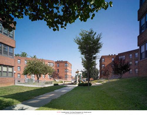 a view of a sidewalk between two brick buildings
