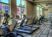 Thumbnail 5 of 17 - A gym with treadmills, elliptical machines, and a stationary bike.