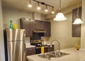 Thumbnail 8 of 17 - A kitchen with a stainless steel refrigerator and a sink.