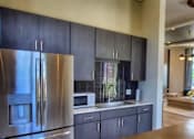 Thumbnail 12 of 17 - A modern kitchen with a wooden table and stainless steel appliances.