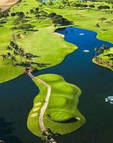 an aerial view of a golf course and a body of water