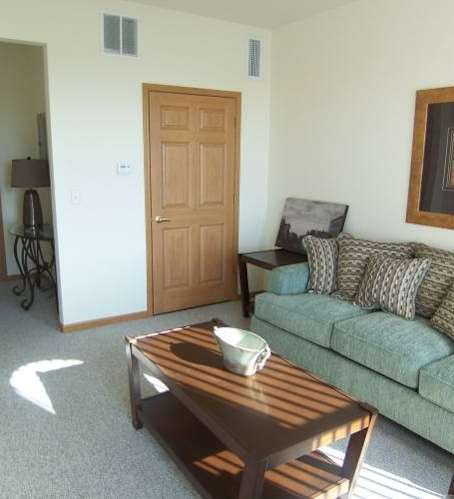 a living room and kitchen with a couch and a table