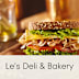 A sandwich with lettuce, tomato, and meat on a wooden table.
