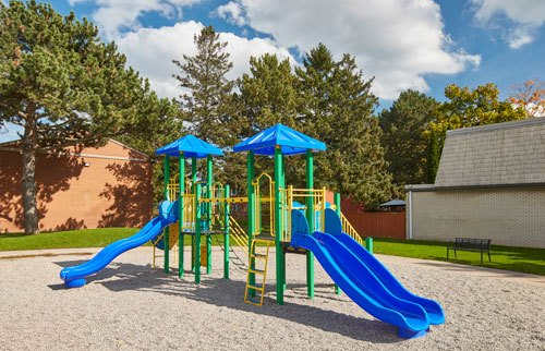 Kids playground area with slide and sandy area.