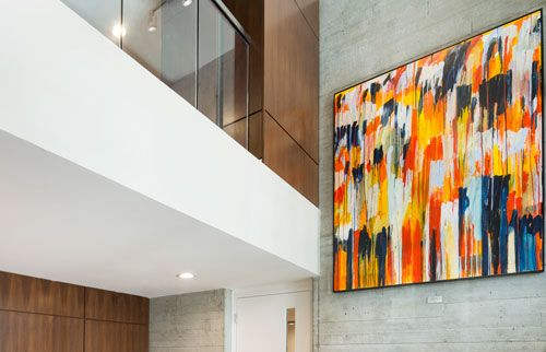 Lobby area with seating, high ceiling and a large painting