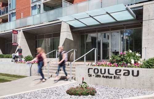 exterior of building with a sign that says Rouleau and two people walking